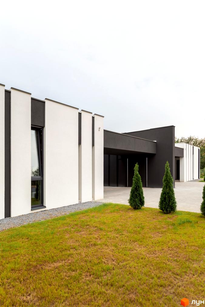 Duplex Comfort House - новобудова з білими та темними фасадами, великим вікном та зеленою прибудинковою територією з туями.