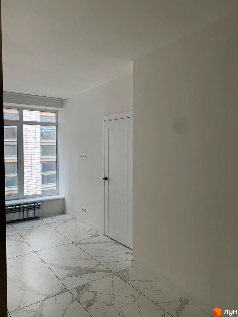 Клубний будинок „На Макіївській“: простора кімната з великим вікном та білими стінами, підлога з мармуровою плиткою.