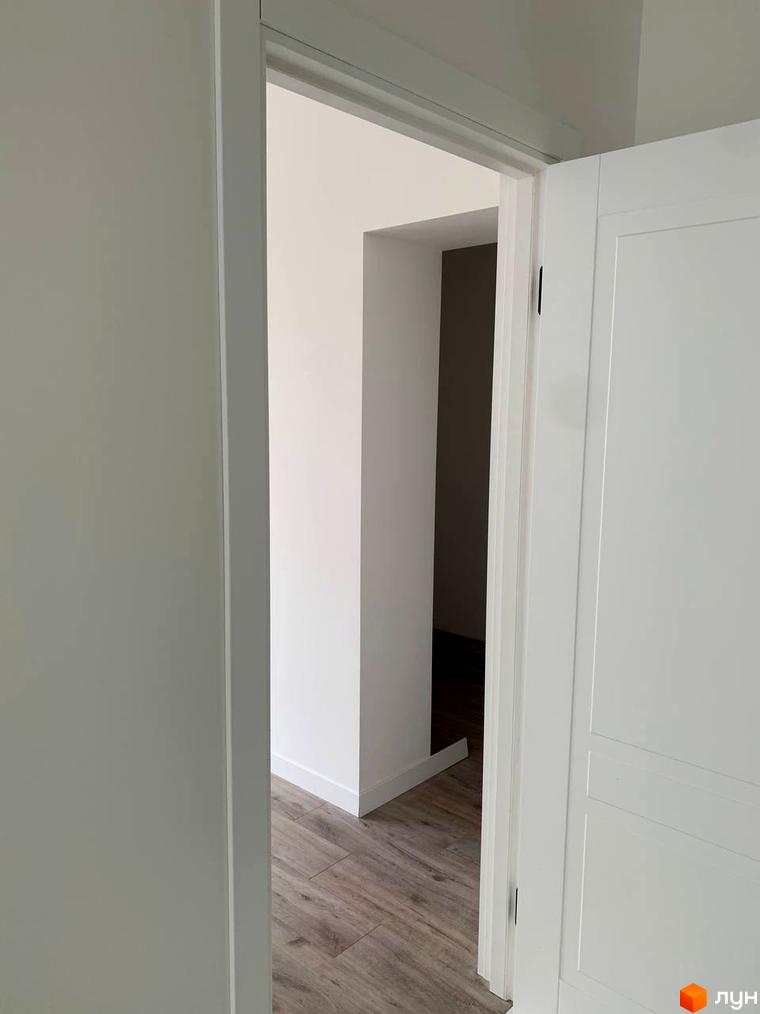 Клубний будинок „На Макіївській“: дверний отвір та біла дверна коробка з видом на кімнату з дерев'яною підлогою.