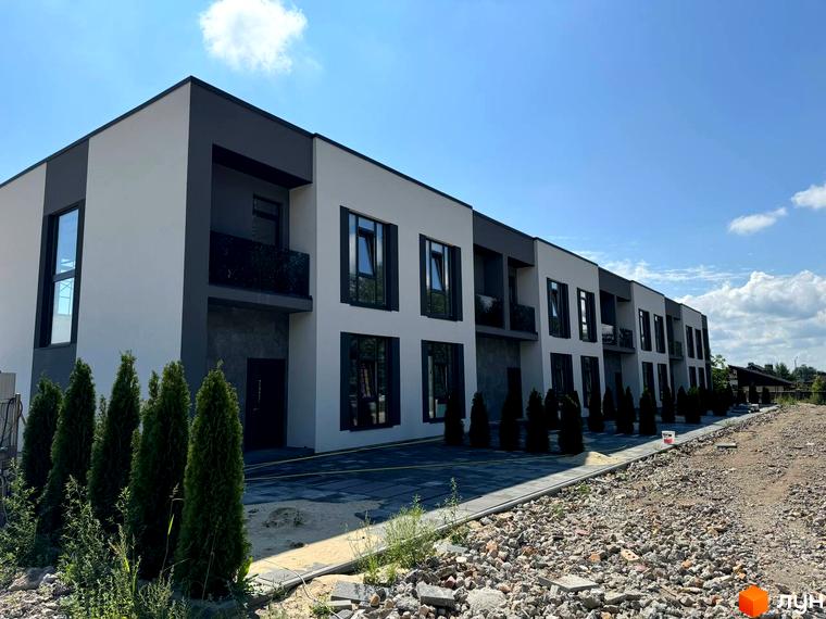 Зовнішній вигляд таунхаусів Osocor Apart. На фото видно фасади будинків, балкони та зелені насадження на прибудинковій території.