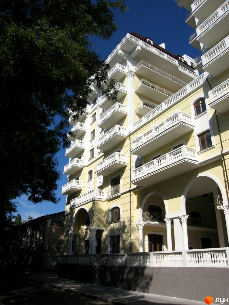 Житловий комплекс ЖК Ренесанс з балконами та арками, оточений зеленими насадженнями та тротуаром.