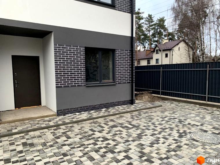 Таунхаус „На Котляревського“ з білим, темно-сірим фасадом та чорною цеглою. Вимощене подвір'я з бруківки сірих відтінків.