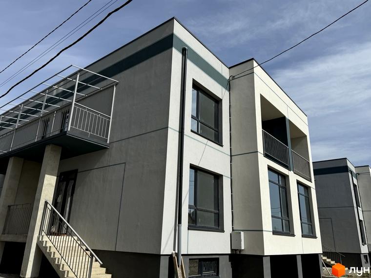 Зовнішній вигляд таунхаусів 4Family House з сірими та білими фасадами, великими вікнами та балконами. Навколо будівель видно елементи прибудинкової території.