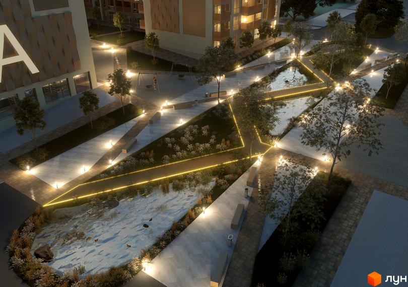 Житловий комплекс AUROOM DISTRICT з архітектурним освітленням та доглянутою прибудинковою територією з водоймою, лавками та деревами.