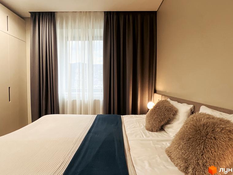 Затишна спальня в апарт-комплексі Крайобраз з великим ліжком, подушками та шторами, що створюють атмосферу комфорту та спокою.