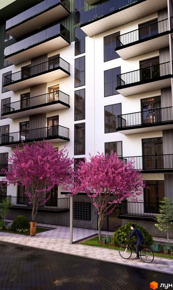 Фасад Житлового комплексу Home з білими стінами, темними вікнами та балконами. Прибудинкова територія з рожевими квітучими деревами та доріжками.