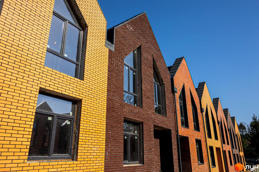 Зовнішній вигляд таунхаусів FORT HOMES з цегли різних кольорів. Видно вікна та покрівлю будинків.