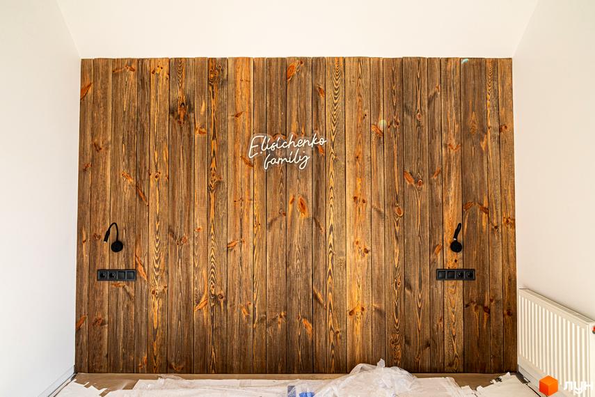 Дизайн спальні з дерев'яною стіною та підсвічуванням 