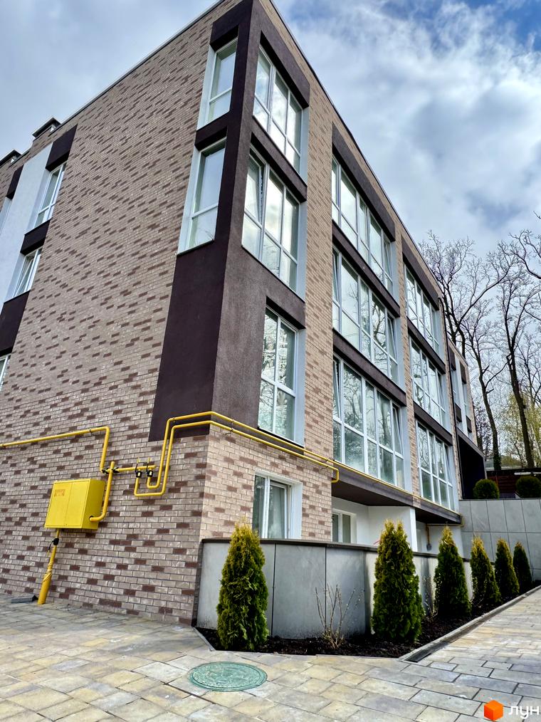 Зображення фасаду та прибудинкової території Житлового комплексу Light Residence. На передньому плані тротуарна плитка та зелені насадження.