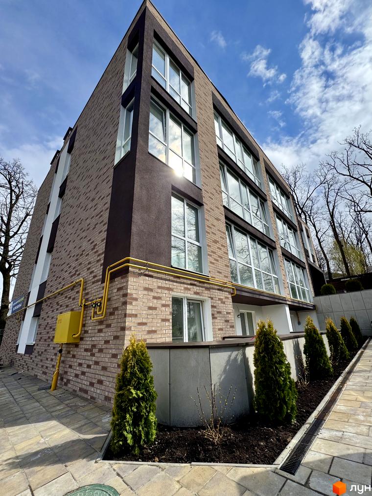 Зображення фасаду будинку в Житловому районі Light Residence. На передньому плані видно озеленену прибудинкову територію.