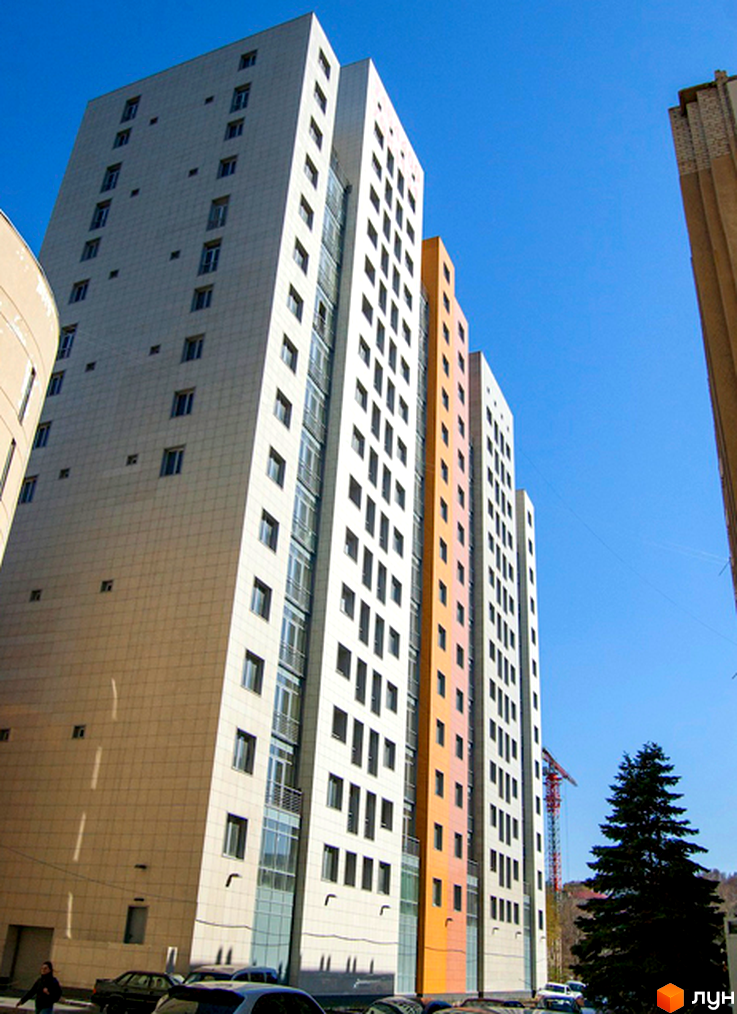 Житловий комплекс Duet у Києві. Сучасна архітектура, високі будівлі з панорамними вікнами та балконами. Навколо зелені насадження та доглянута територія.