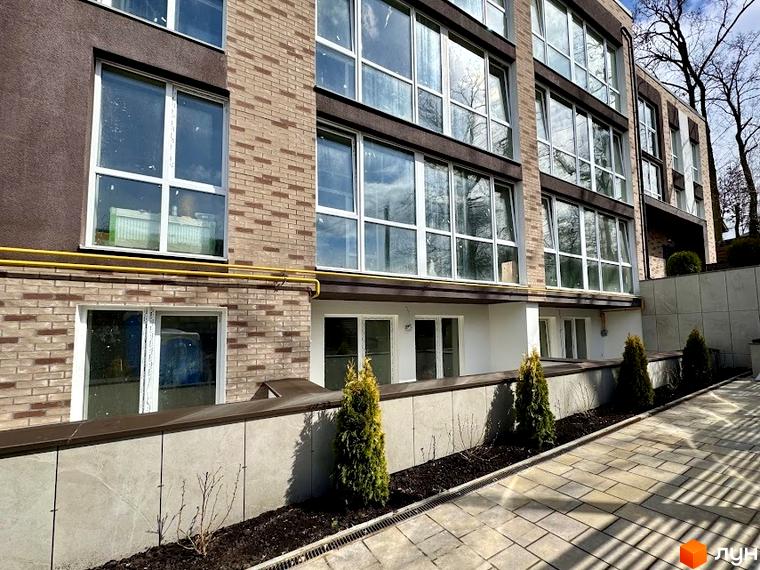 Зовнішній вигляд будинку в Житловому комплексі Light Residence з великими вікнами та прибудинковою територією з декоративними рослинами.