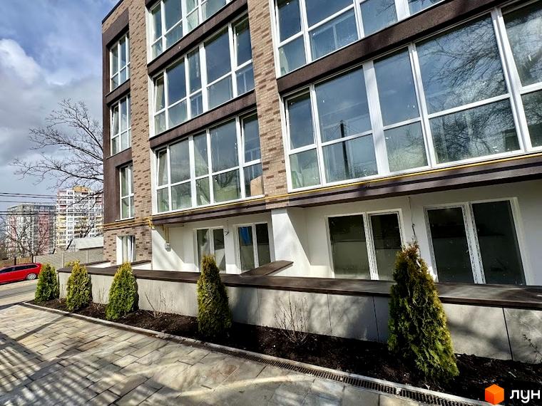 Зовнішній вигляд Клубного будинку Light Residence. Фасад з великими вікнами та озеленення прибудинкової території.