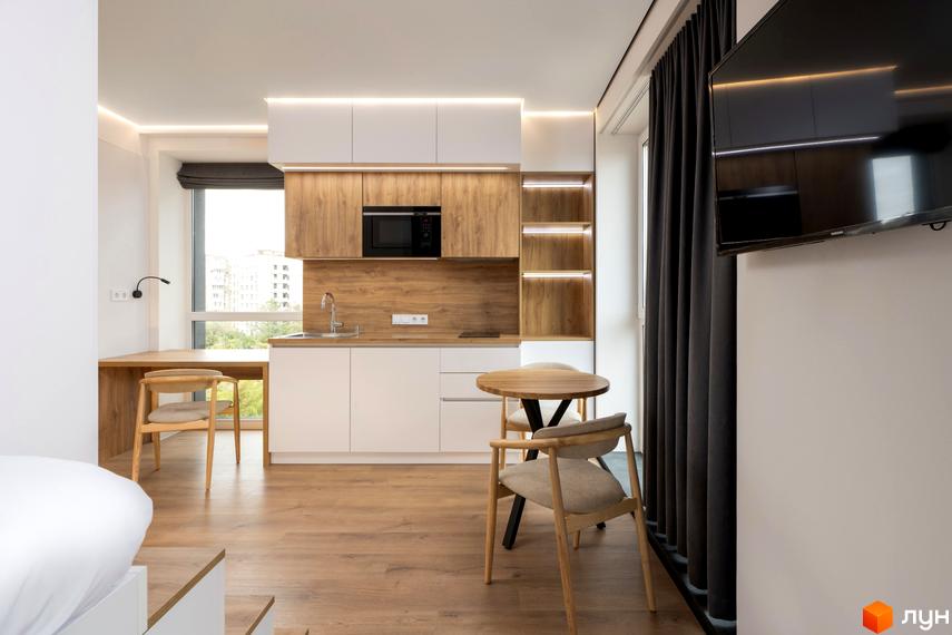 Сучасний інтер'єр квартири-студії в житловому комплексі К11 з кухнею, обідньою зоною та робочим місцем біля вікна.