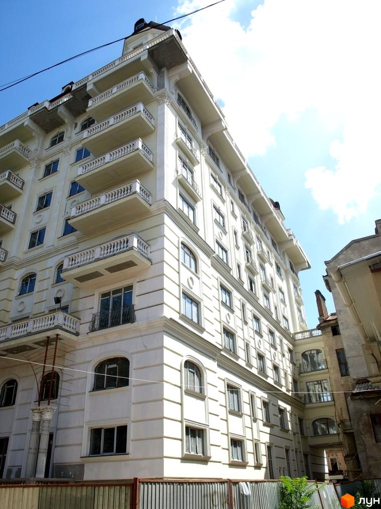 Житловий комплекс Ренесанс з балконами та великими вікнами. Прибудинкова територія з зеленими насадженнями.