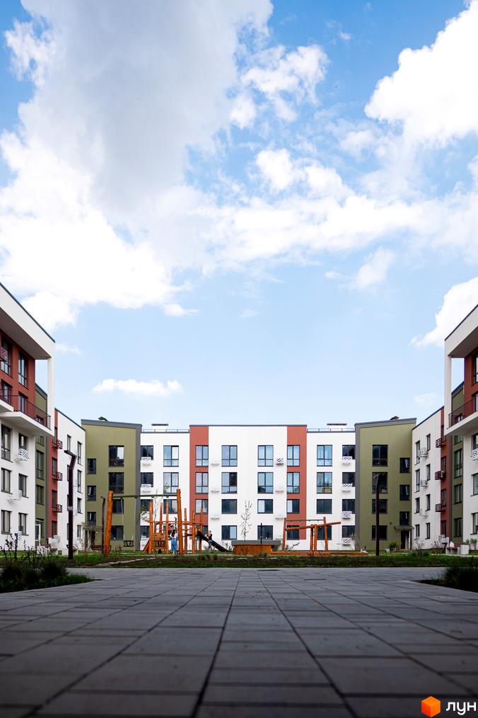 Житловий комплекс Субурбія. Будинки з різнокольоровими фасадами та дитячим майданчиком у дворі.