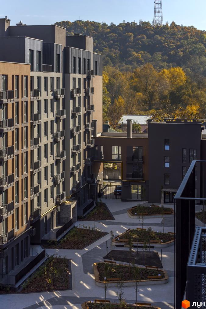 Житловий комплекс Avalon Yard: фасади будівель з балконами та прибудинкова територія з ландшафтним дизайном та місцями для відпочинку.