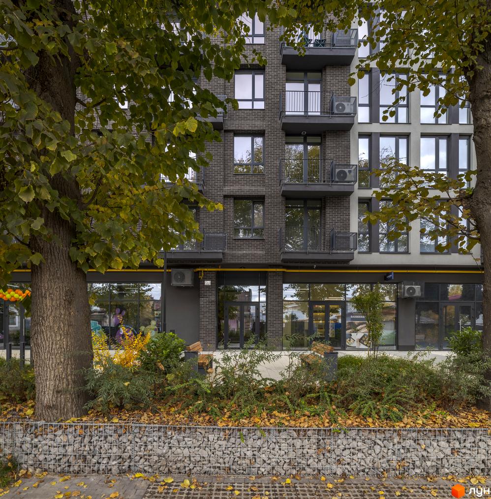 Житловий комплекс Avalon Yard з цегляним фасадом та балконами, оточений деревами з осіннім листям.