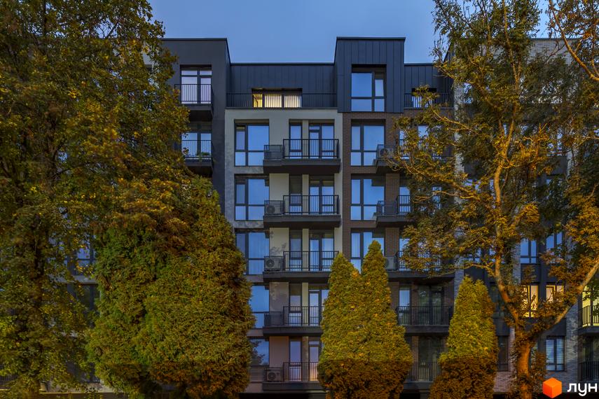 Житловий комплекс Avalon Yard - це багатоповерхова новобудова з балконами та великими вікнами, оточена деревами.