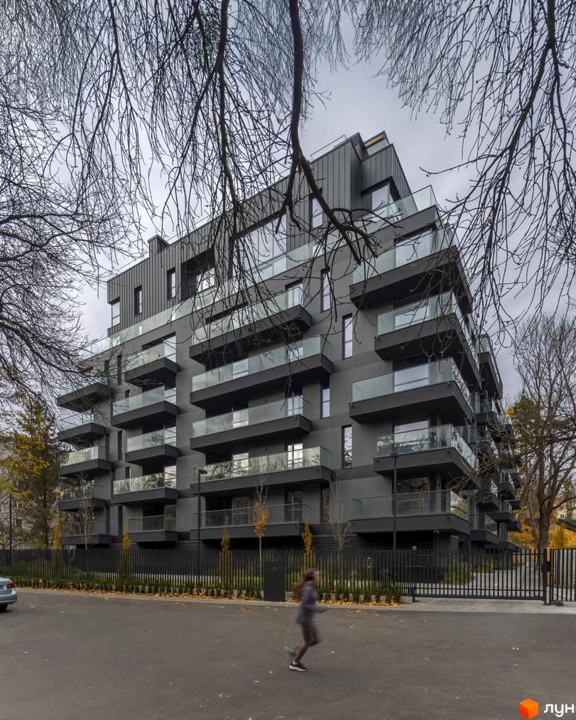 Житловий комплекс Avalon Prime – це багатоповерхова новобудова з балконами та скляними огорожами, розташована біля паркану та доглянутої прибудинкової території.