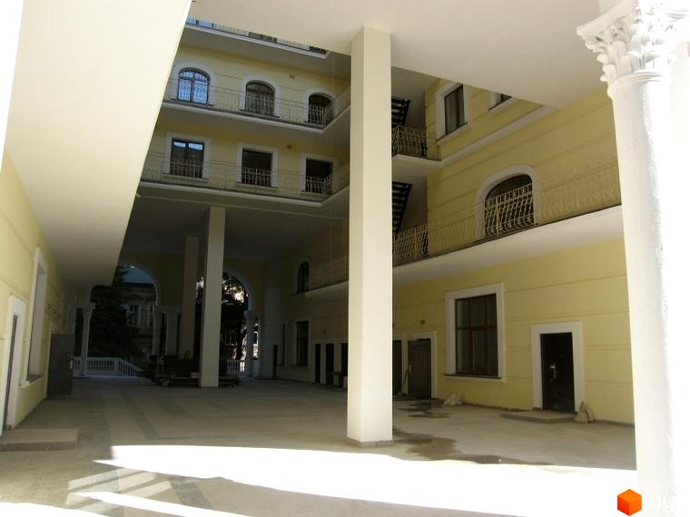 Внутрішній двір житлового комплексу ЖК Ренесанс з колонами та балконами. Простора прибудинкова територія з озелененням.