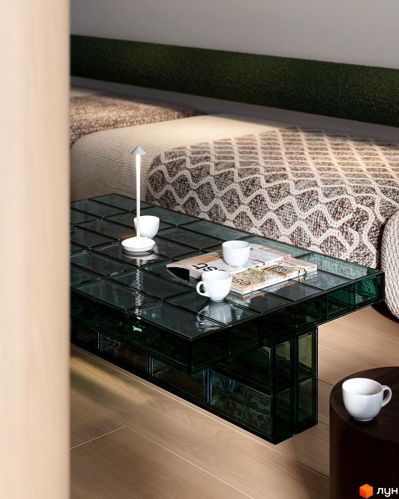 Інтер'єр житлової кімнати в Житловому комплексі Avalon Magnolia: ліжко з покривалом, скляний кавовий столик з чашками.