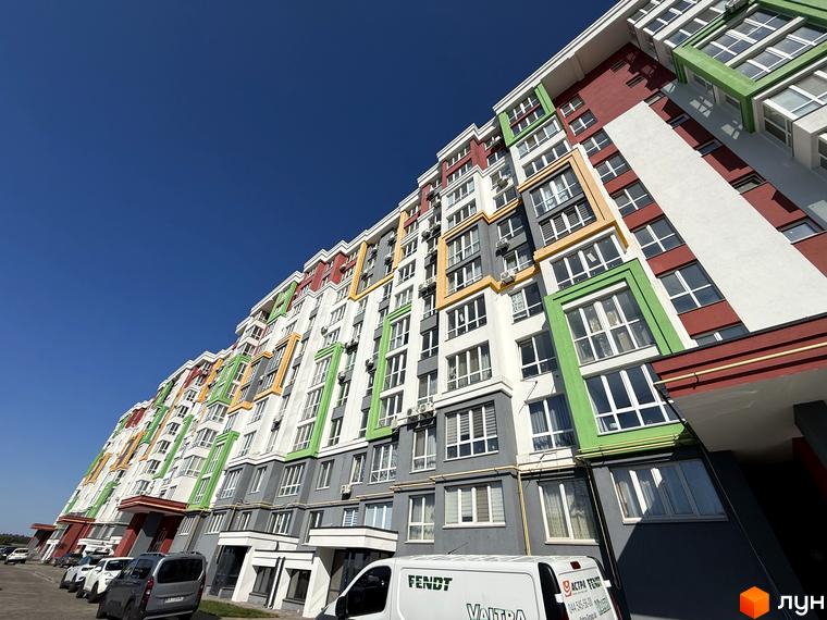 Зовнішній вигляд багатоповерхового будинку Житлового комплексу Добре Місто 2 з кольоровим фасадом та великими вікнами.