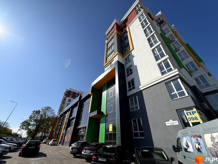 Зовнішній вигляд багатоповерхового будинку Житловий комплекс Добре Місто 2 з парковкою та автомобілями.