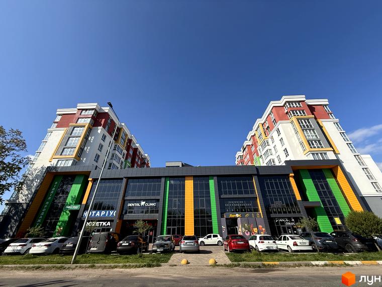 Зовнішній вигляд Житлового комплексу Добре Місто 2 з яскравим фасадом та комерційними приміщеннями на першому поверсі.