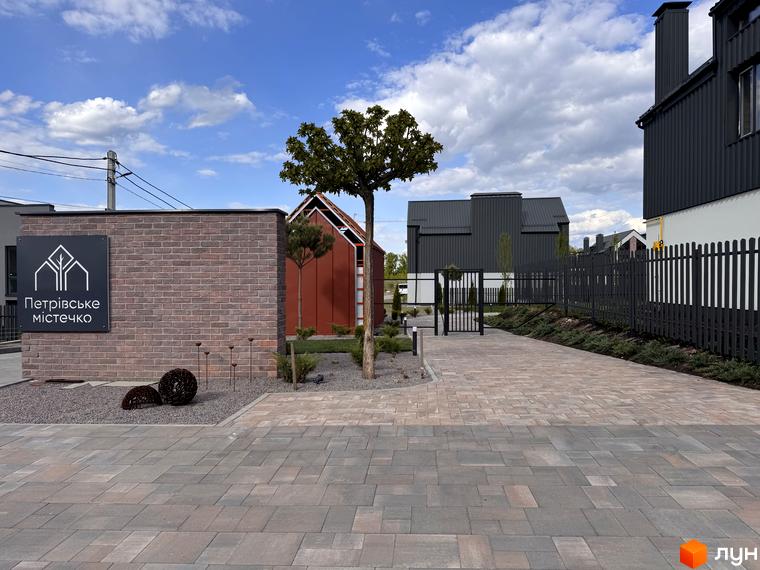 Вхідна група та фасади таунхаусів Петрівське містечко. Озеленена прибудинкова територія з бруківкою та парканом.