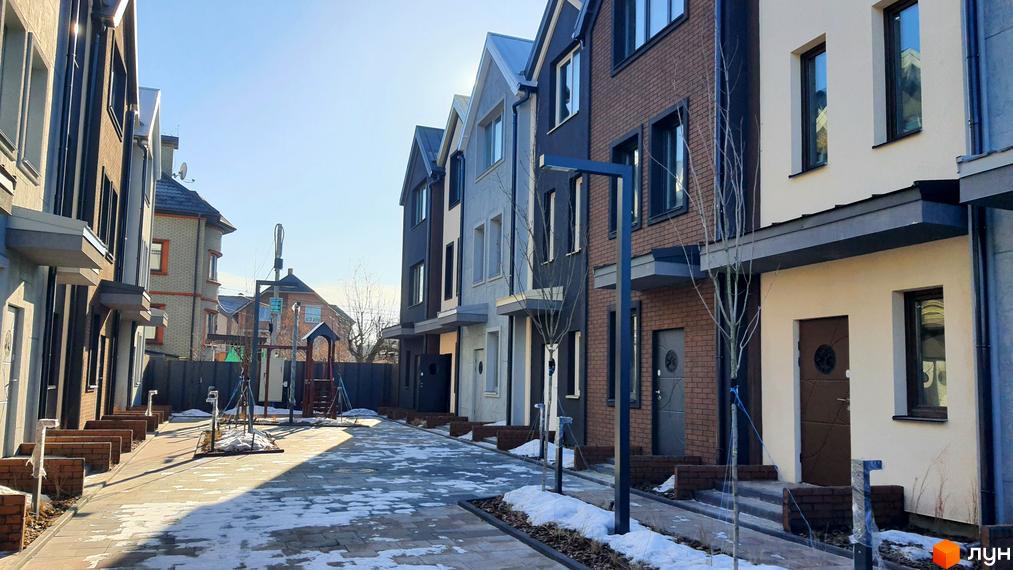 Фото таунхаусів New Smart 12. Вигляд будівель з оздобленням фасаду та вимощеною бруківкою прибудинковою територією.