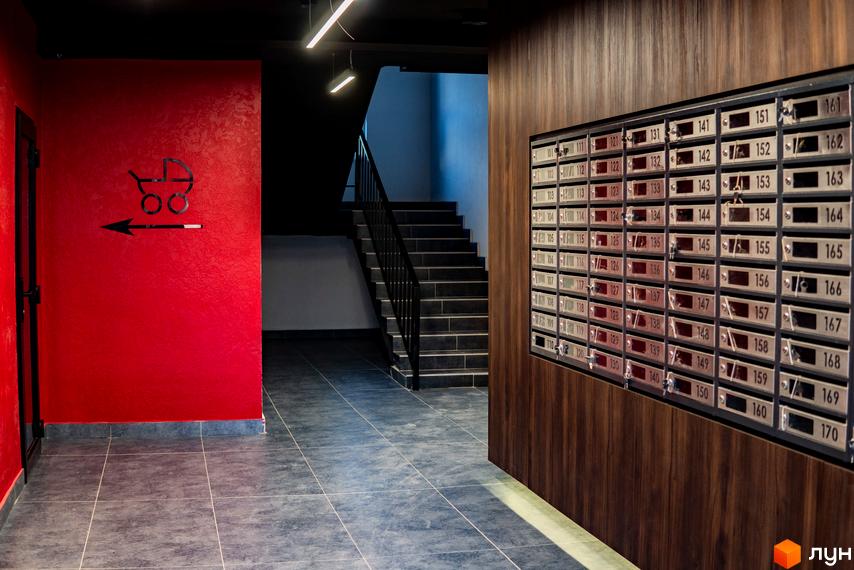 Інтер'єр ЖК IQ House: поштові скриньки з номерами квартир, вказівник на дитячу кімнату, сходи на верхні поверхи.