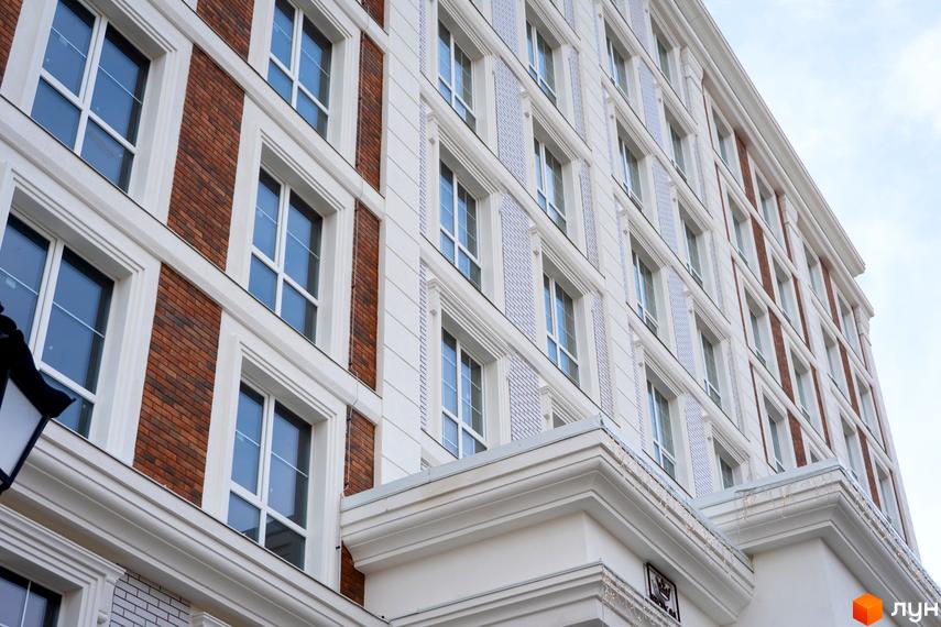 Фасад житлового комплексу OXFORD з цегляними та білими елементами, великими вікнами та декоративними карнизами. Зовнішній вигляд будівлі.