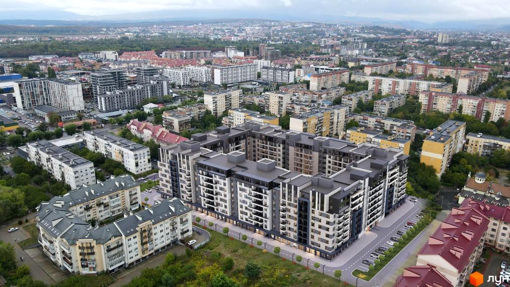 Зовнішній вигляд житлового комплексу GARDEN CITY з багаторівневими фасадами та балконами, прибудинкова територія з дорогою та парковкою.