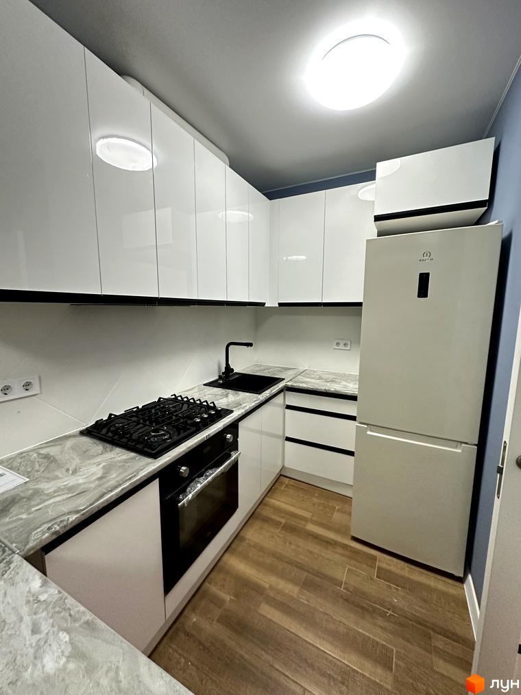 Сучасна кухня з білими глянцевими фасадами, вбудованою технікою та мармуровою стільницею. Затишна атмосфера для вашого дому.