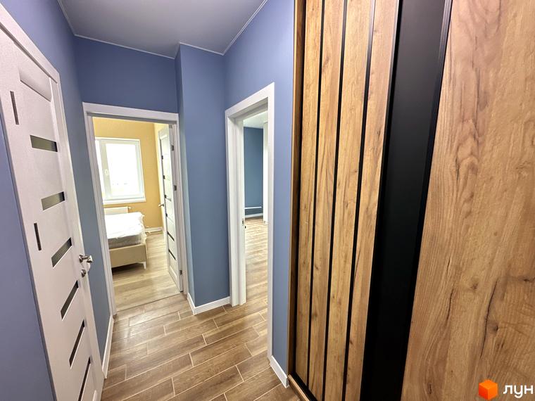 Дизайн коридору в ЖК Комфортне містечко з дверима та шафою з дерев'яними елементами. Інтер'єр новобудови з акцентом на природні матеріали.