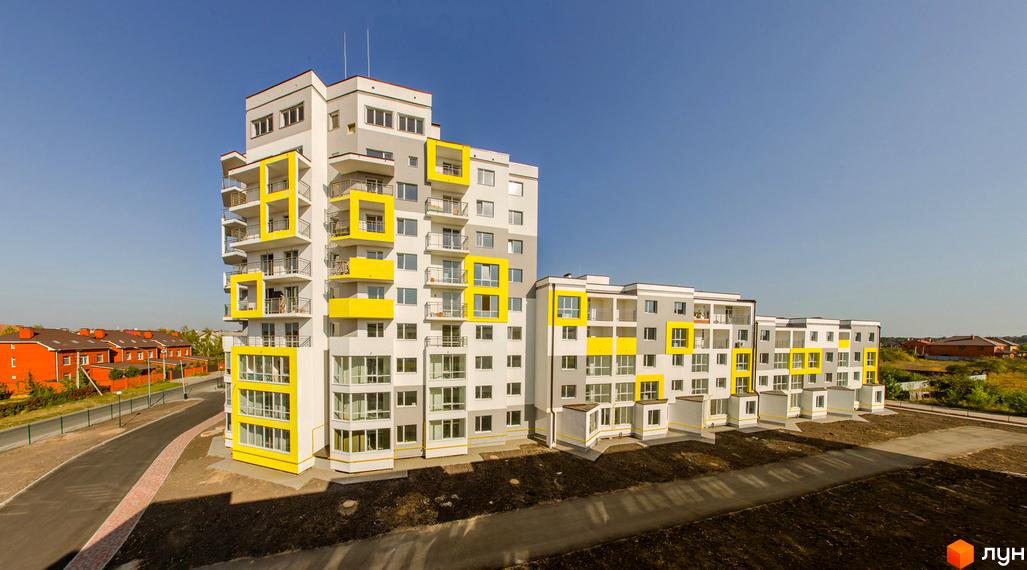 Житловий комплекс Сан Сіті - сучасна багатоповерхова новобудова з яскравими жовтими елементами та балконами. Навколо комплексу розташована доглянута прибудинкова територія з дорогою.