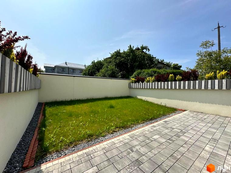 Зовнішній вигляд будинку ЖК на вулиці Івана Гонти. Прибудинкова територія з газоном, вимощенням та огорожею.