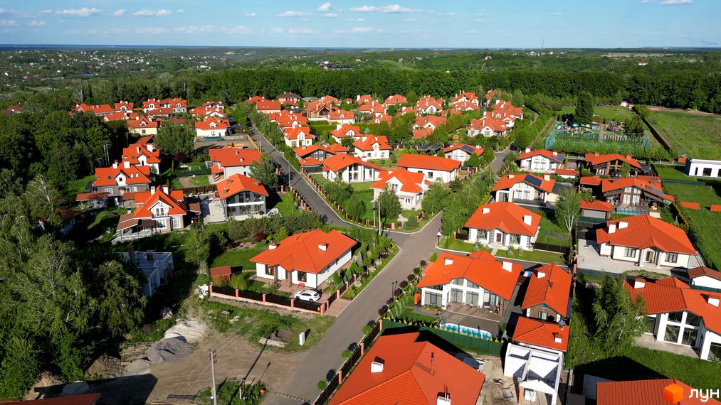 Фото Котеджне містечко Рославичі з висоти пташиного польоту. Будинки з червоними дахами та зеленою прибудинковою територією.