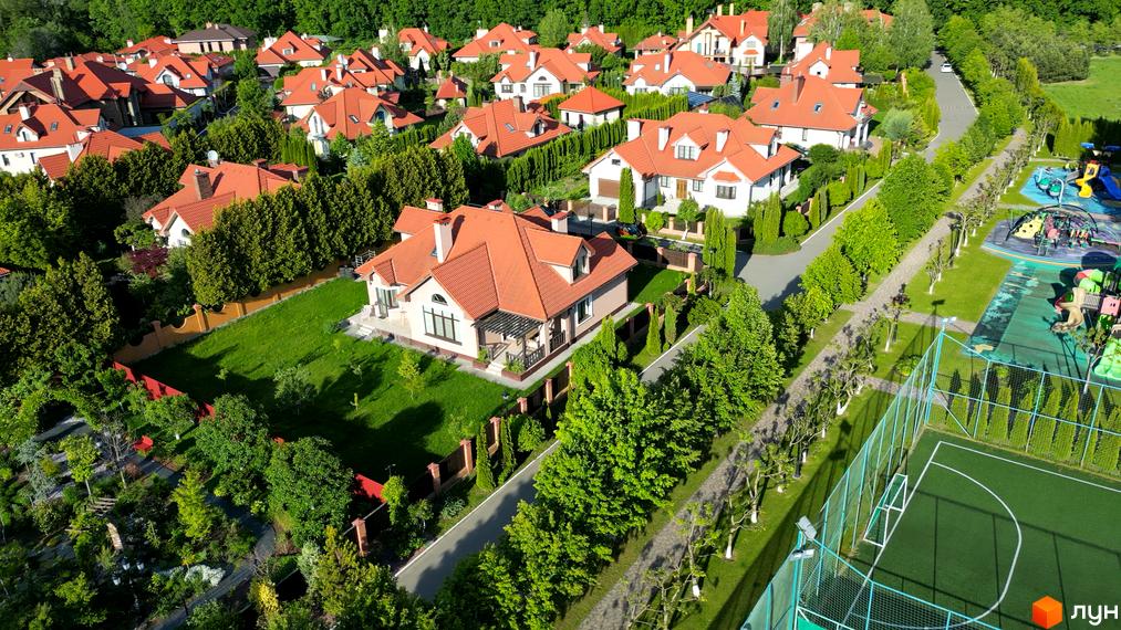 Вигляд Котеджного містечка Рославичі з висоти пташиного польоту. Будинки з теракотовими дахами, зелені газони та доглянута територія.