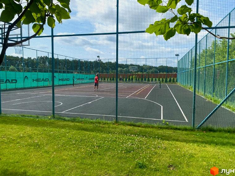Зображення тенісного корту в Котеджному містечку Рославичі. Спортивний майданчик з сіткою та розміткою для гри в теніс.
