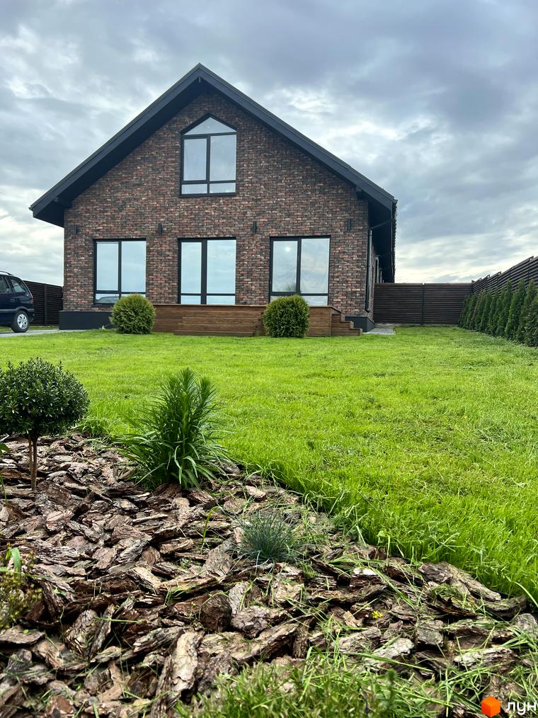 Котеджне містечко КМ Одноповерховий Київ-Осокорки: цегляний будинок з великими вікнами та доглянутою зеленою прибудинковою територією.