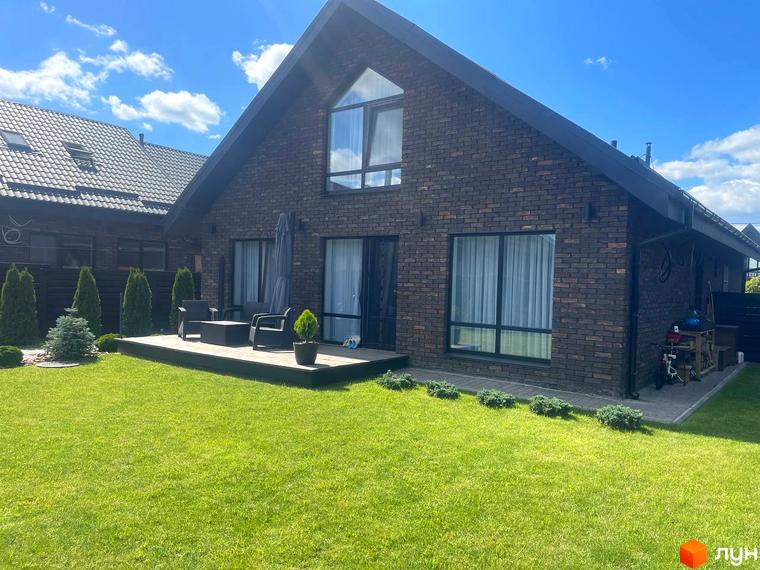 Котеджне містечко Одноповерховий Київ-Осокорки: цегляний будинок з великими вікнами та терасою, зелений газон та доглянута прибудинкова територія.