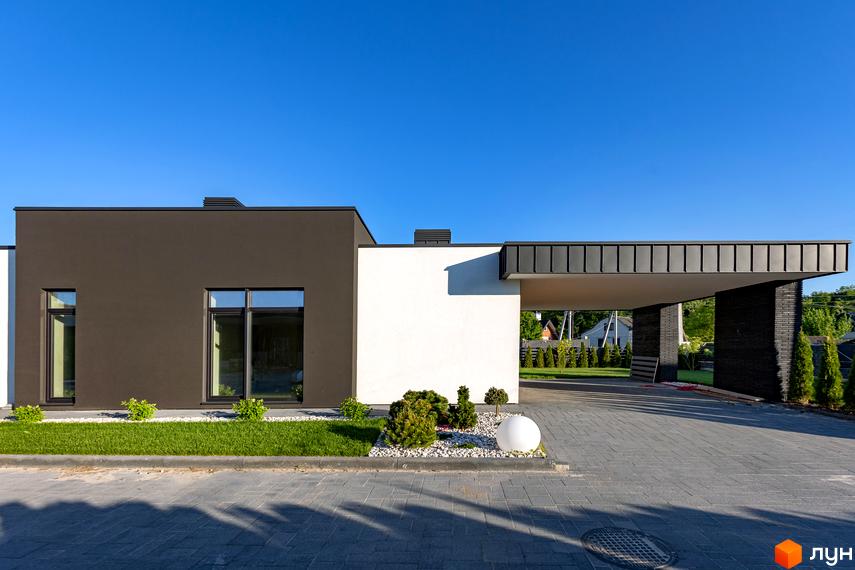 Котеджне містечко КМ Terra Solis. Сучасний будинок з темною та білою стіною, великими вікнами, навісом для авто та вимощеною територією.