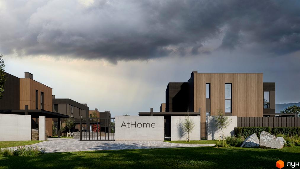 Зображення сторінки Котеджне містечко AtHome. Будинки з дерев'яним оздобленням фасаду, великі вікна, вхідна група з написом та зелена прибудинкова територія.