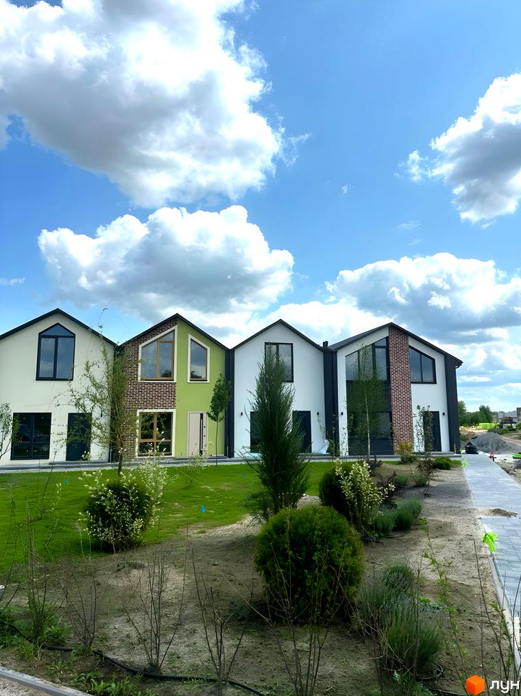 Зображення сторінки житлового комплексу Сітіхауси PRO MISTO. На фото ряд будинків з білими та зеленими фасадами, великими вікнами та доглянутою прибудинковою територією.