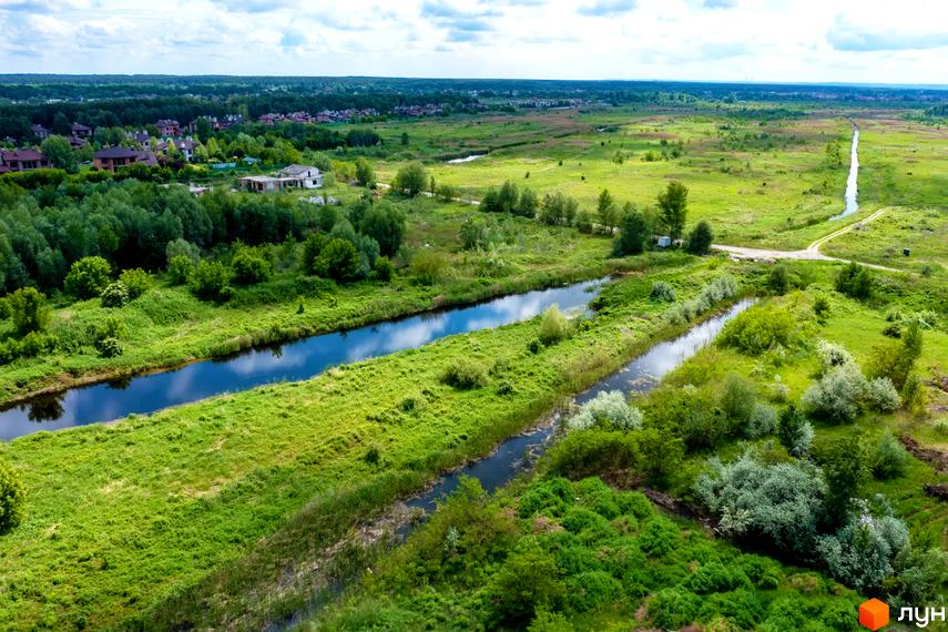 Котеджне містечко Piemont eco village з мальовничими краєвидами та каналами. Зелена територія навколо новобудов.
