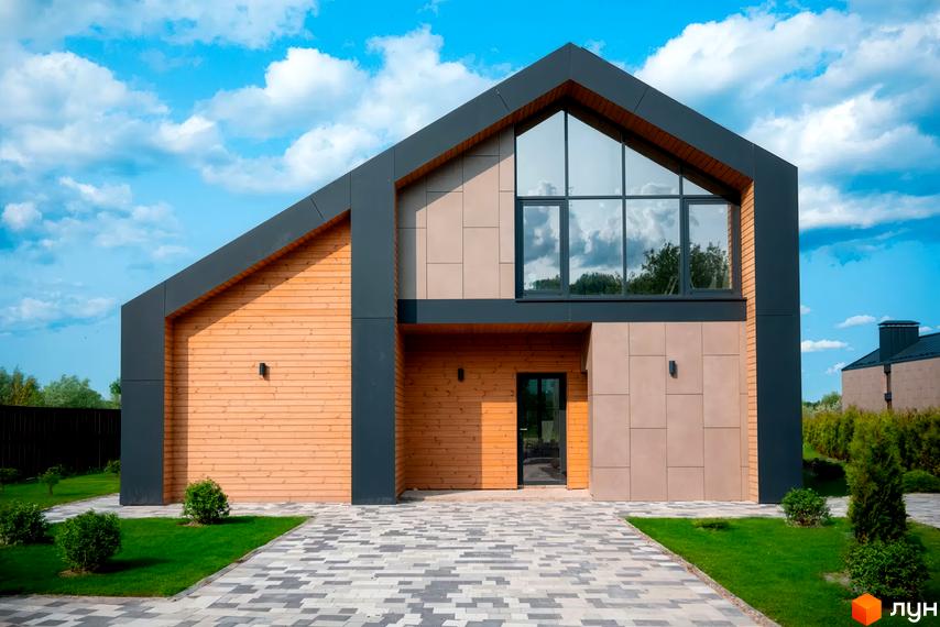 Котеджне містечко КМ Piemont eco village: двоповерховий будинок з дерев'яним фасадом, великим вікном та доглянутою прибудинковою територією.