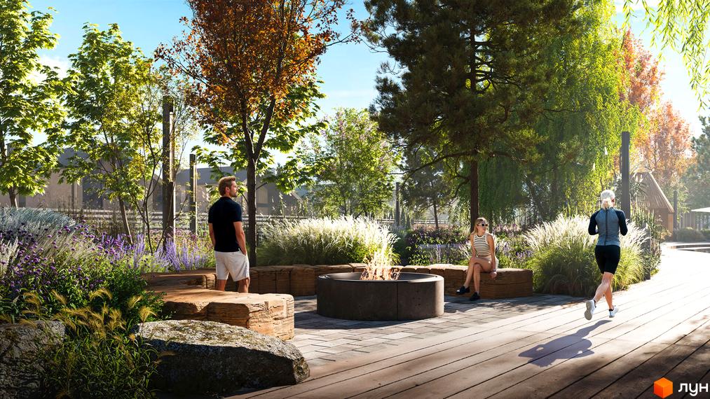 Котеджне містечко КМ Piemont eco village з зоною відпочинку біля вогнища та людьми, що займаються спортом на території.