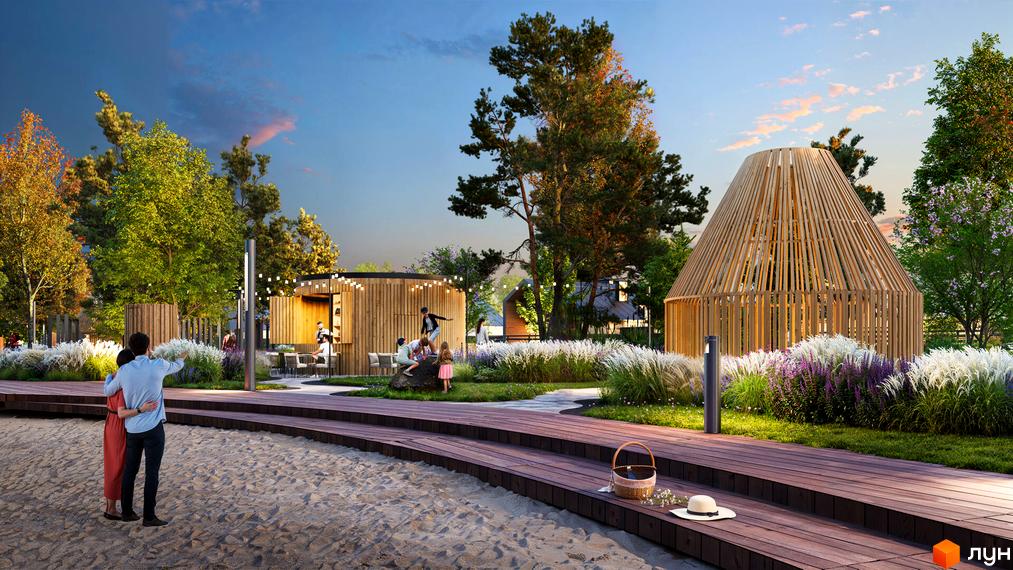 Котеджне містечко Piemont eco village. На зображенні видно дерев'яний павільйон та конічну альтанку, оточені піщаним пляжем, дерев'яним настилом та зеленими насадженнями.